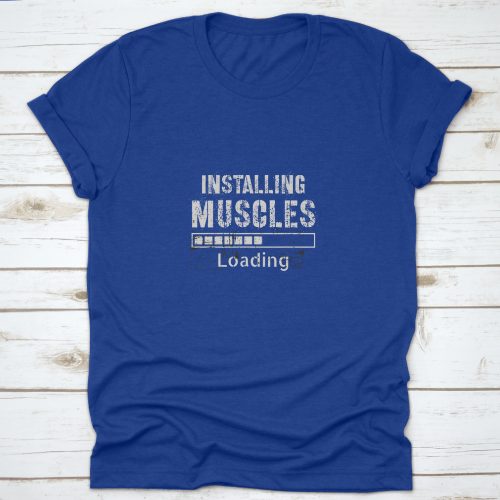 A vintage-inspired t-shirt featuring a grunge background with the phrase 'Installing Muscles', made from 100% cotton for comfort.