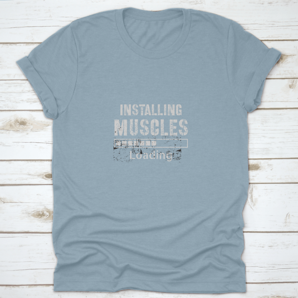 A vintage-inspired t-shirt featuring a grunge background with the phrase 'Installing Muscles', made from 100% cotton for comfort.