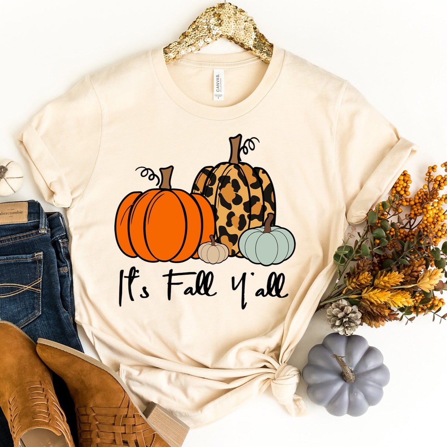 A stylish It's Fall Y'all Tee in a cozy autumn setting, showcasing its comfortable fabric and modern fit.