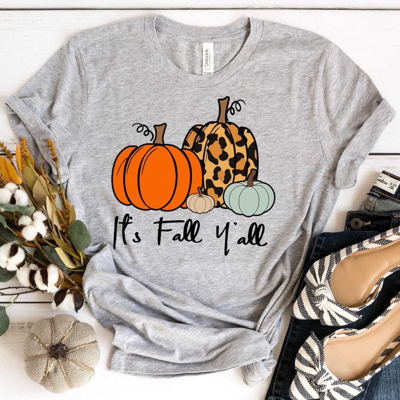 A stylish It's Fall Y'all Tee in a cozy autumn setting, showcasing its comfortable fabric and modern fit.