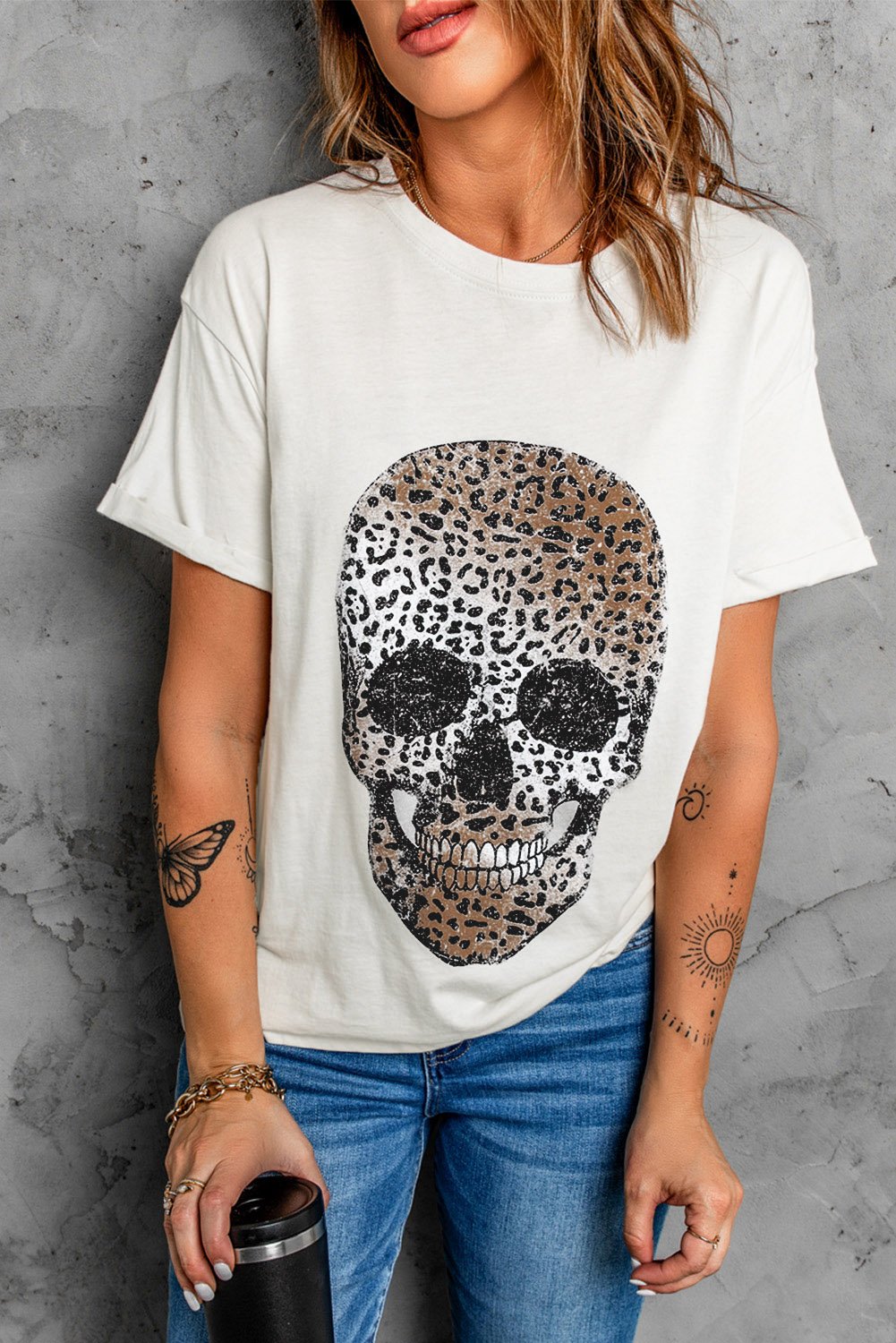 A stylish white t-shirt featuring a bold leopard skull graphic print on the front, showcasing a casual and trendy design.