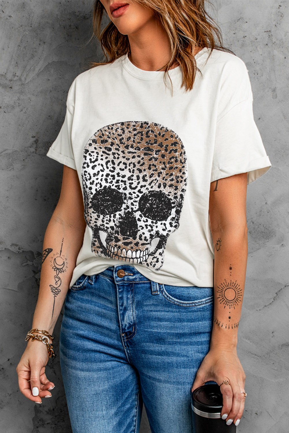 A stylish white t-shirt featuring a bold leopard skull graphic print on the front, showcasing a casual and trendy design.