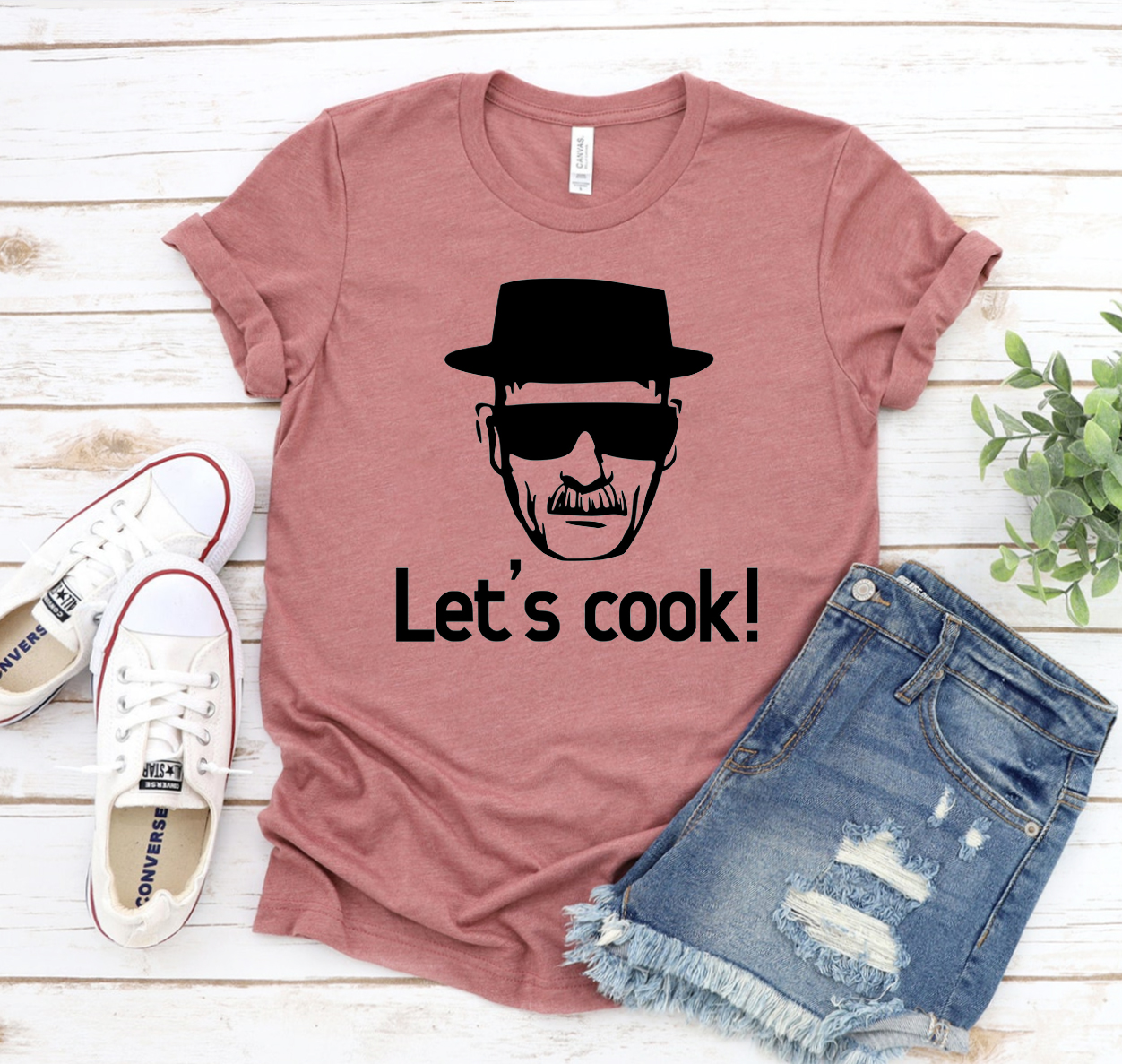 A stylish unisex Lets Cook T-shirt made from soft airlume cotton, featuring a classic design suitable for all cooking enthusiasts.