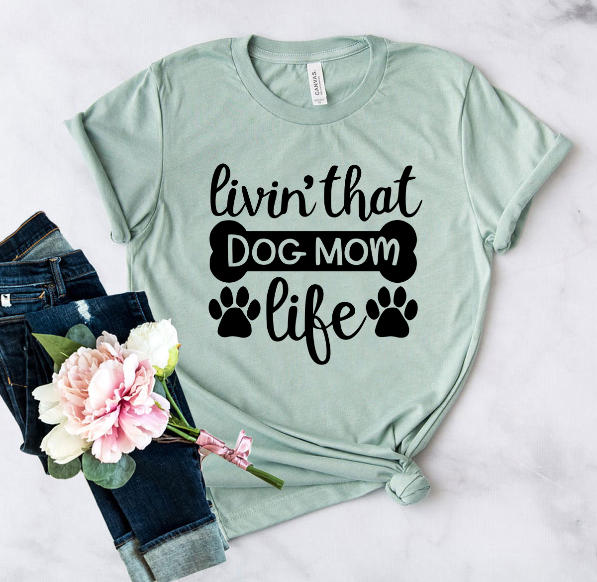 A stylish unisex T-shirt featuring the phrase 'Livin That Dog Mom Life', made from soft ring spun cotton, available in multiple colors.