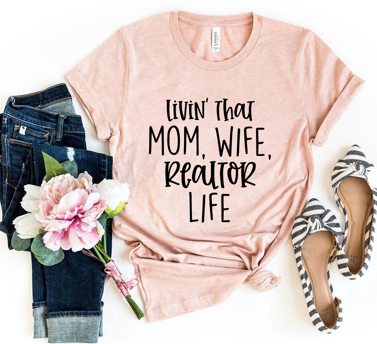 A stylish unisex T-shirt featuring the phrase 'Livin That Mom, Wife, Realtor Life' printed on soft ring spun cotton fabric, available in multiple colors.