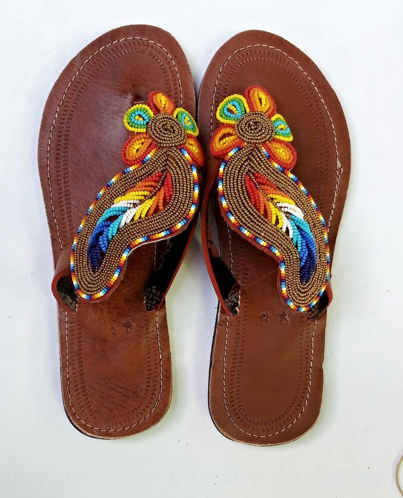 A pair of Maasai Craft Leather Sandals featuring vibrant African beadwork and durable leather, showcasing traditional craftsmanship.