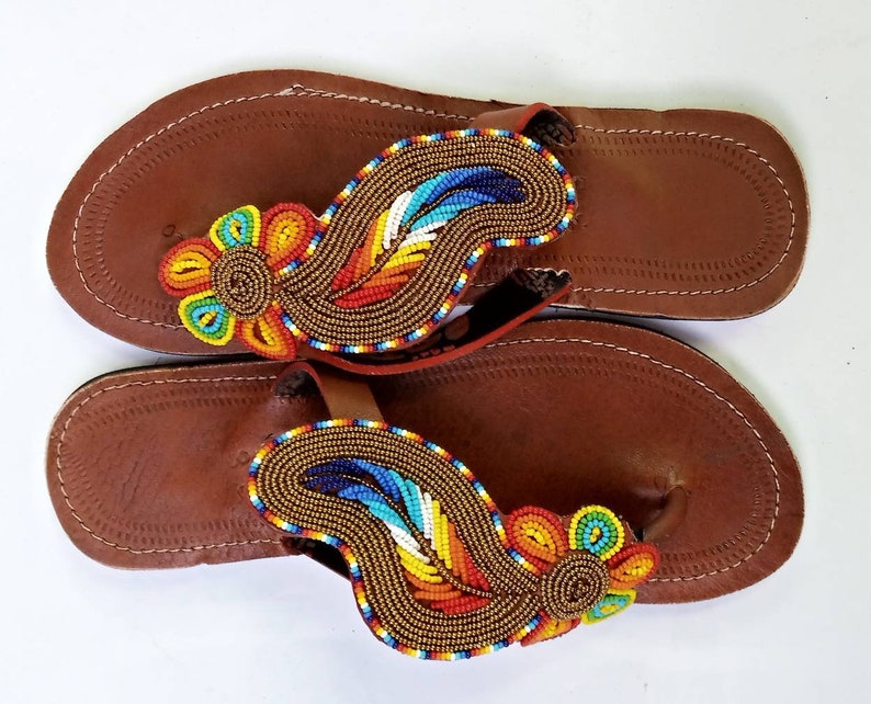 A pair of Maasai Craft Leather Sandals featuring vibrant African beadwork and durable leather, showcasing traditional craftsmanship.