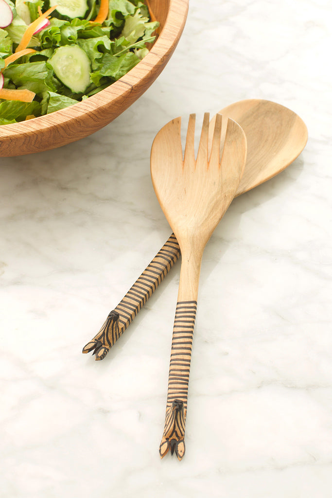 Olive wood salad spoon with a beautifully carved giraffe head, showcasing intricate details and natural wood grain.