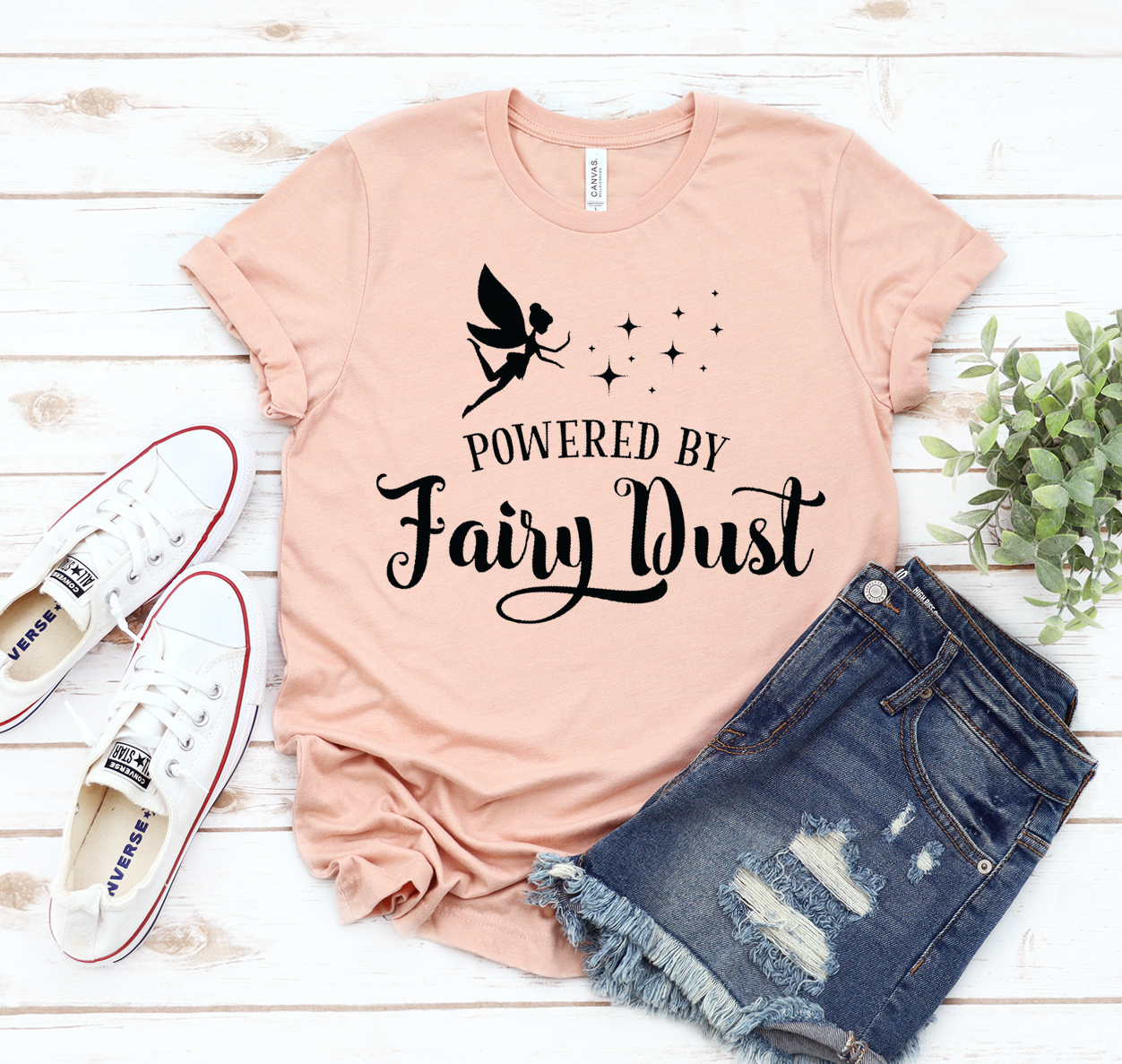 A stylish unisex Powered By Fairy Dust T-shirt made from soft airlume cotton, featuring a whimsical design.