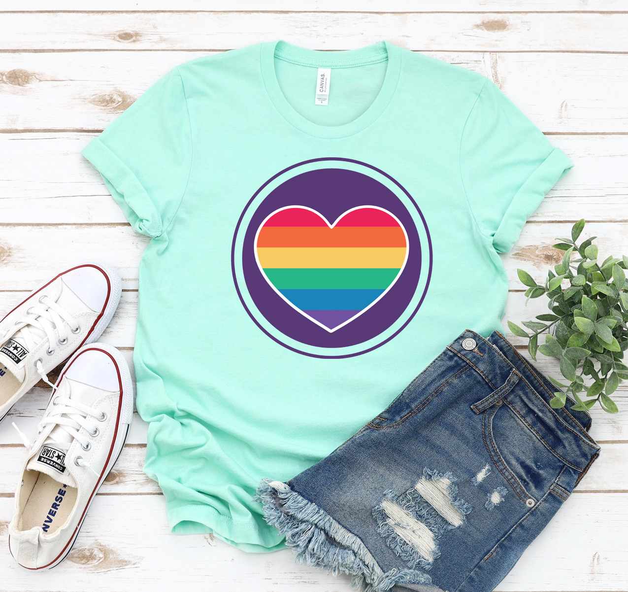 A colorful Rainbow Heart T-shirt displayed on a mannequin, showcasing its vibrant design and soft fabric.