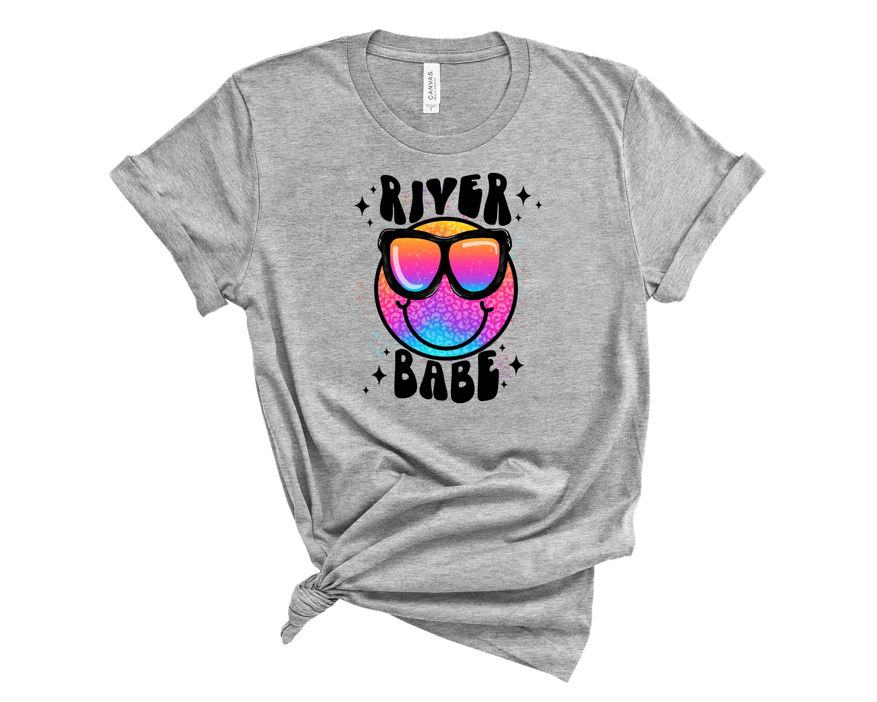 River Babe Smiley Graphic Tee featuring a vibrant smiley design on a soft unisex t-shirt.