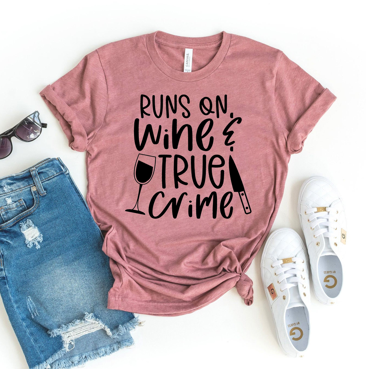 A stylish black t-shirt featuring the phrase 'Runs On Wine And True Crime' in a bold, eye-catching design, made from premium ring spun cotton.