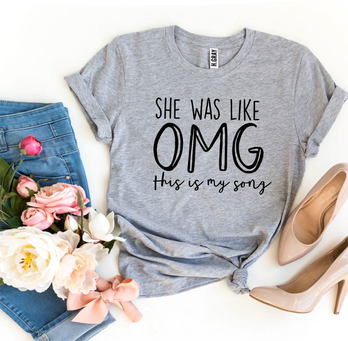 A stylish T-shirt featuring the phrase 'She Was Like OMG This Is My Song', made from soft ring spun cotton with a high-quality print.