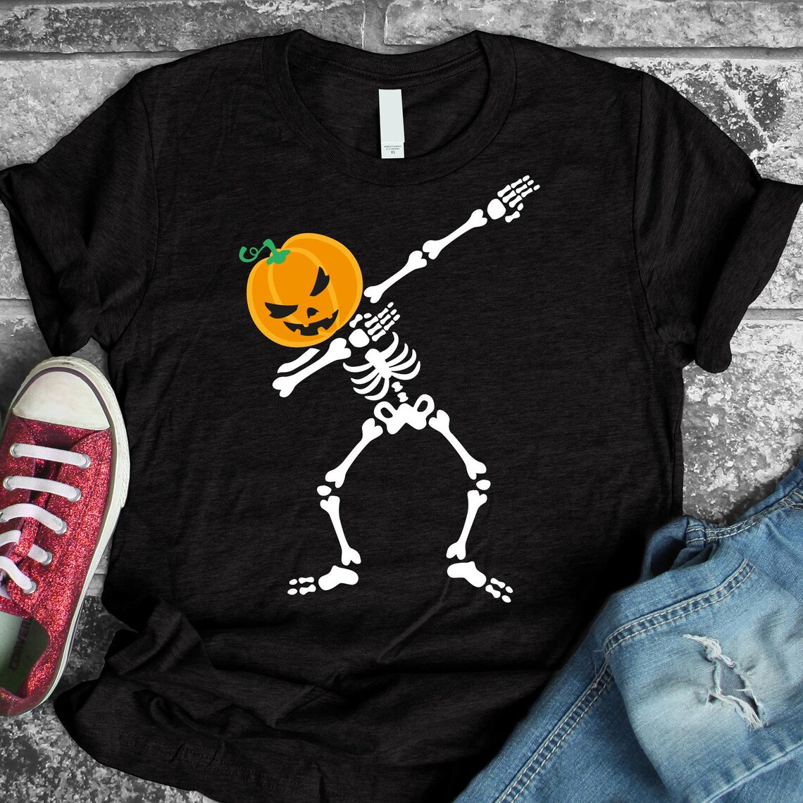 Skeleton Pumpkin Dabbing Halloween T-shirt featuring a vibrant graphic design on premium cotton fabric.