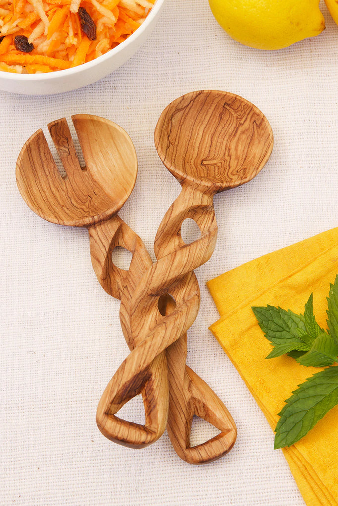 Small olive wood salad server with a seamless spiral handle, handcrafted by Kenyan artisans, showcasing unique grain patterns.