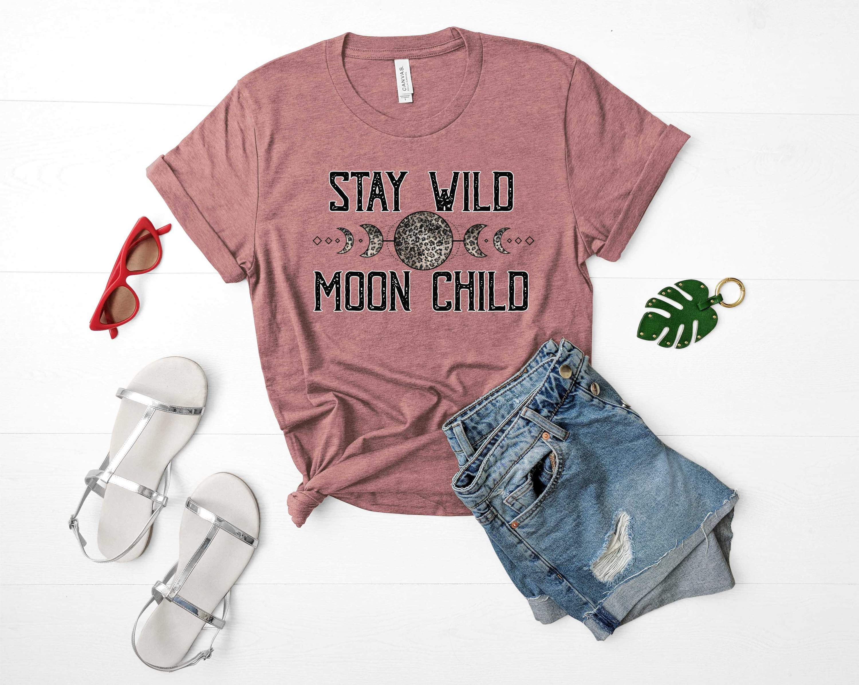 Unisex Stay Wild Moon Child graphic tee featuring a unique moon design on a soft fabric.