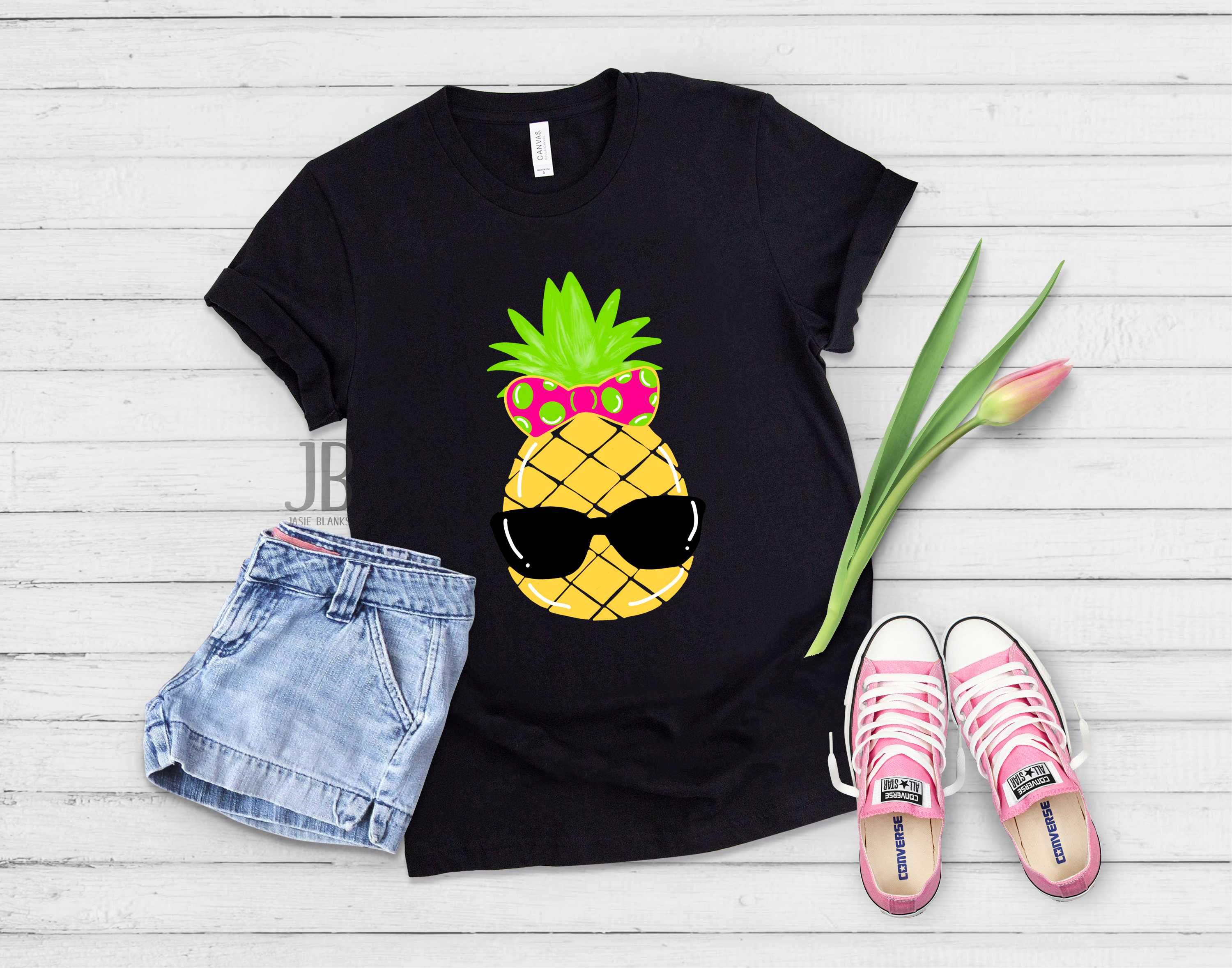 A vibrant unisex summer pineapple graphic tee displayed on a hanger, showcasing its colorful design and soft fabric.