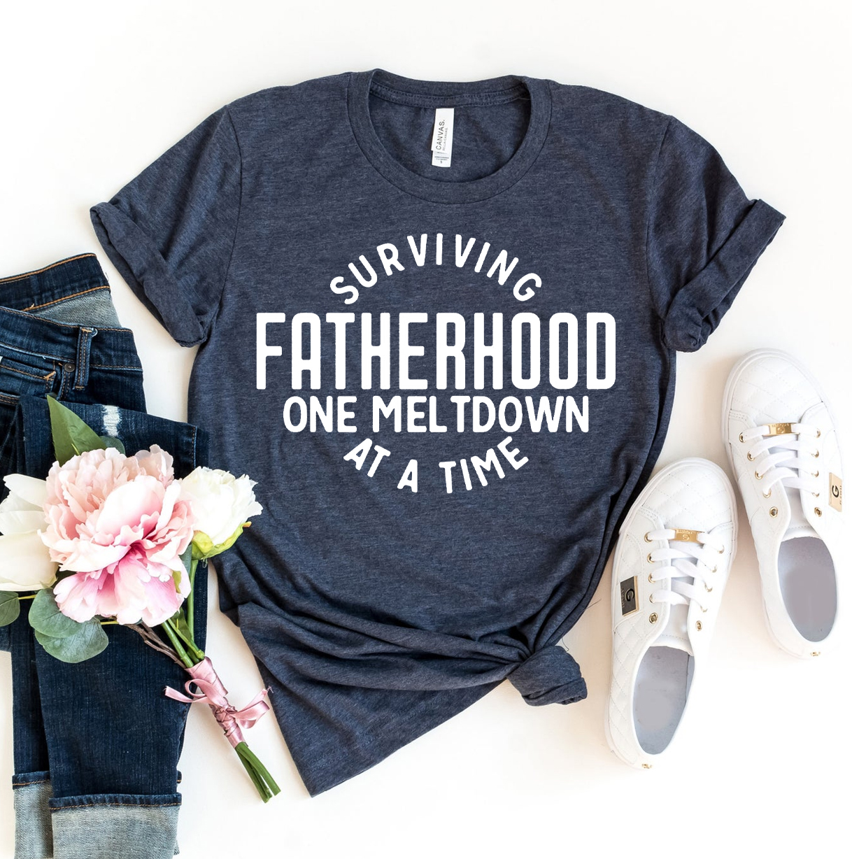 Surviving Fatherhood One Meltdown At A Time T-shirt in various sizes, showcasing its soft cotton fabric and vibrant print.