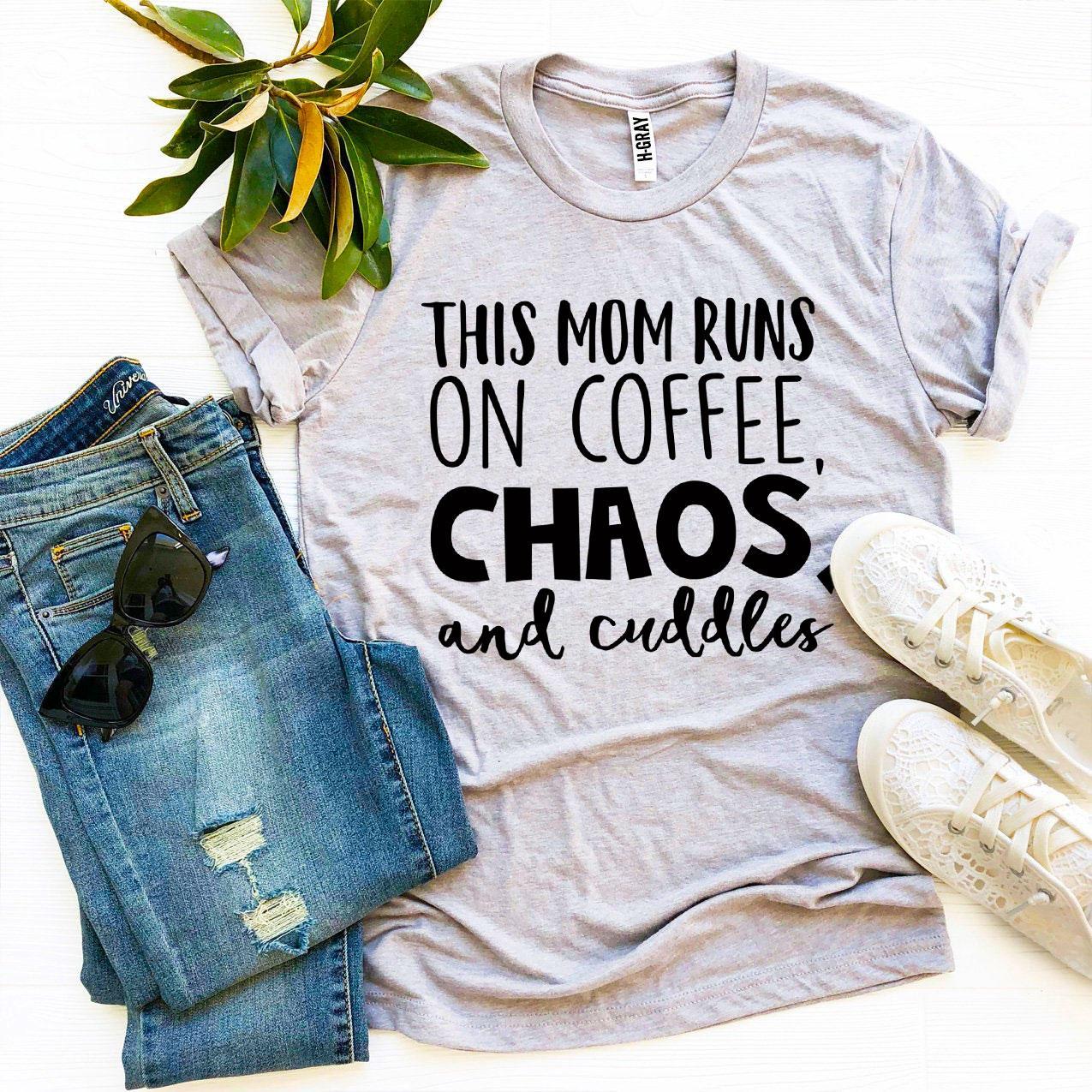 A stylish t-shirt featuring the phrase 'This Mom Runs On Coffee, Chaos, & Cuddles' printed on premium quality cotton fabric.