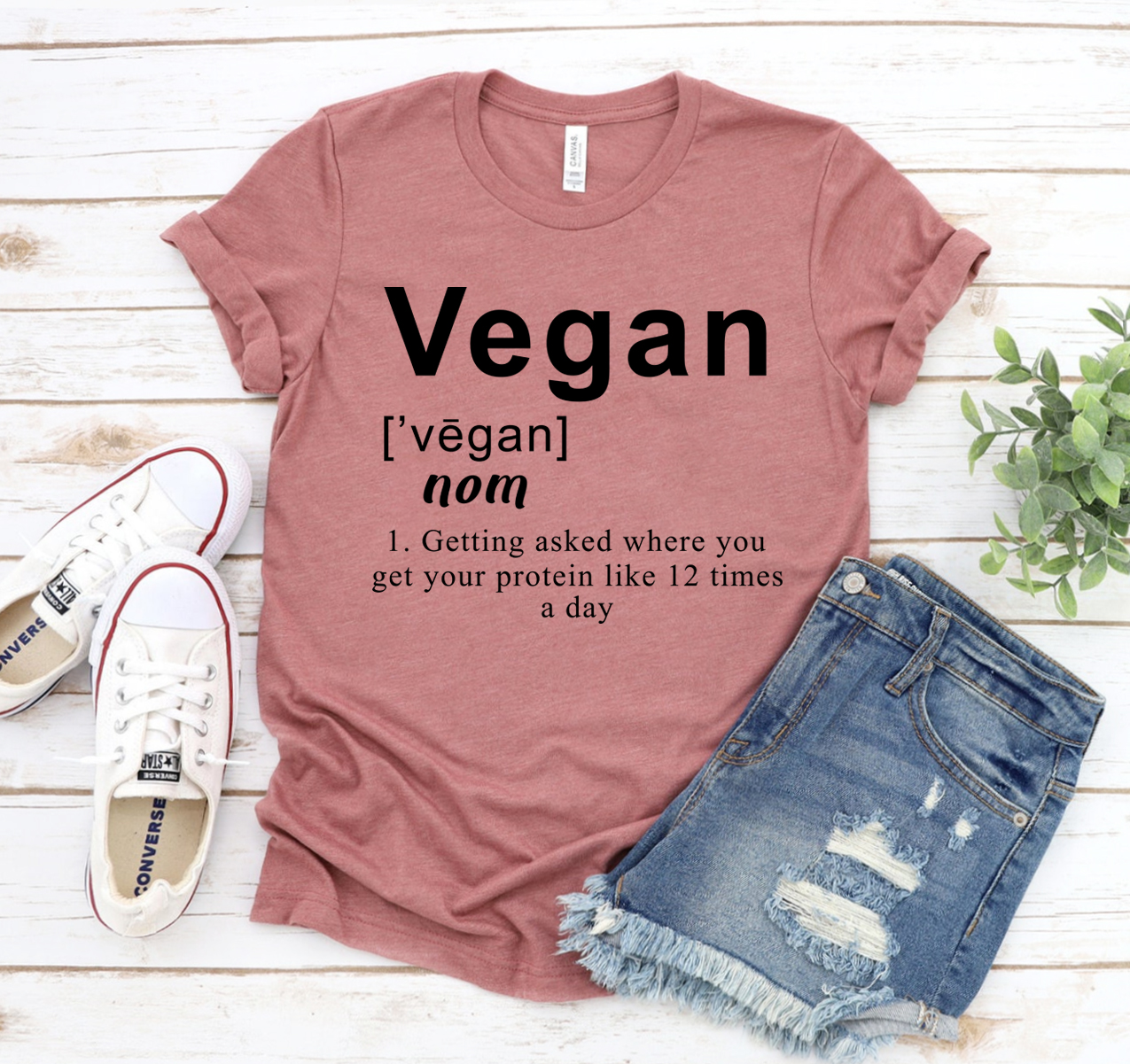 A stylish unisex Vegan Definition T-shirt made from soft airlume cotton, showcasing its comfortable fit and vibrant design.