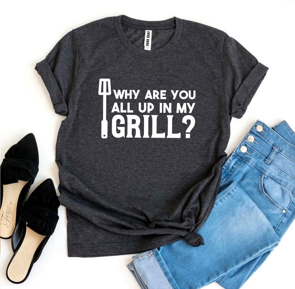 A stylish black t-shirt featuring the humorous slogan 'Why Are You All Up In My Grill?' printed in bold letters, made from soft ring spun cotton.