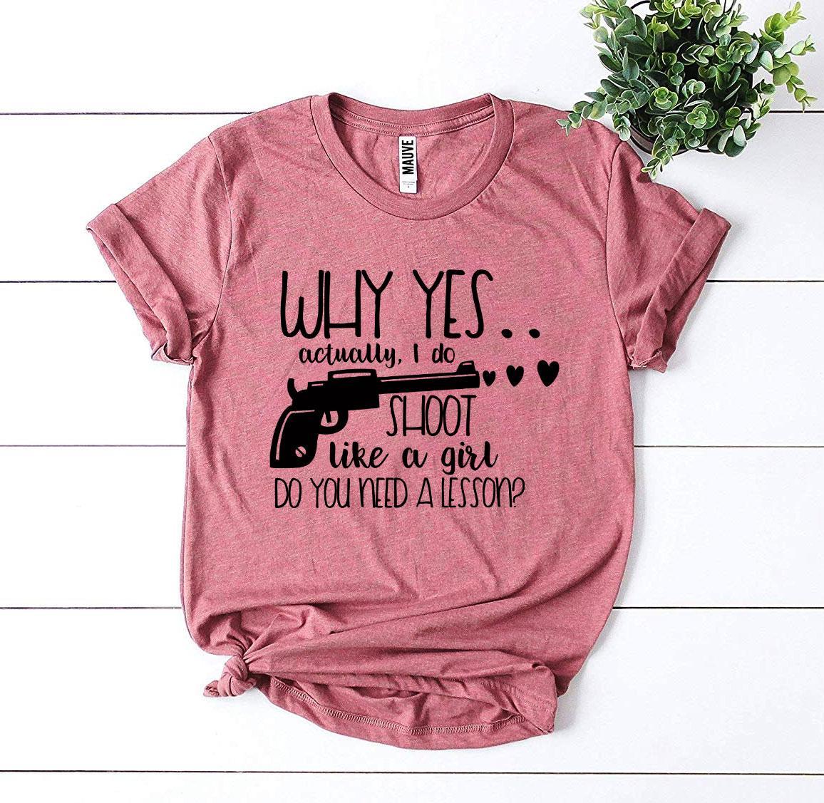 A stylish black t-shirt featuring the phrase 'Why Yes Actually I Do Shoot Like a Girl' in bold print, made from premium quality cotton.