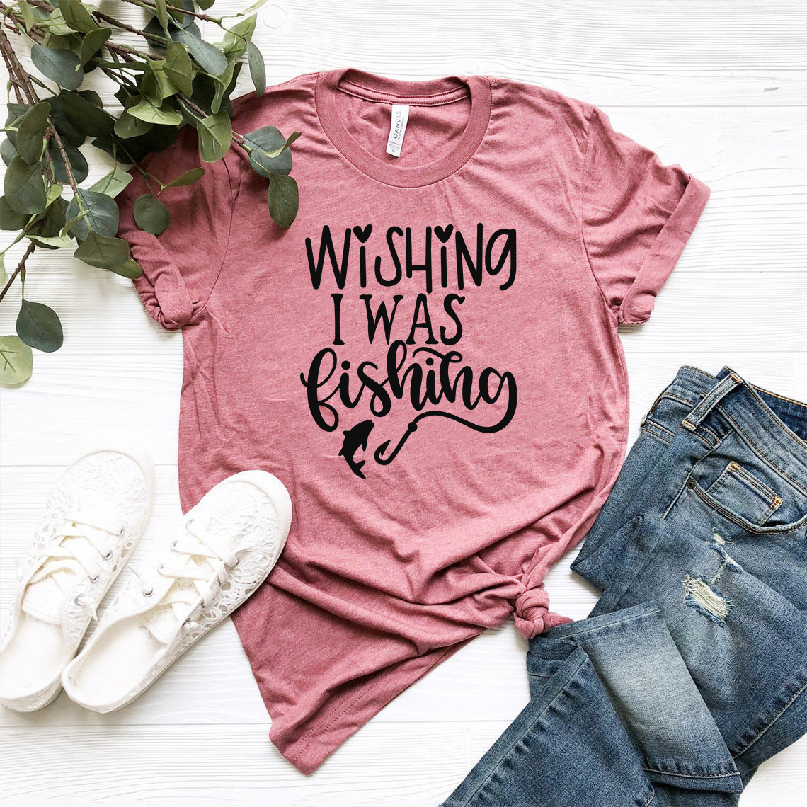 A comfortable unisex T-shirt featuring the phrase 'Wishing I Was Fishing' in vibrant print, available in multiple colors.