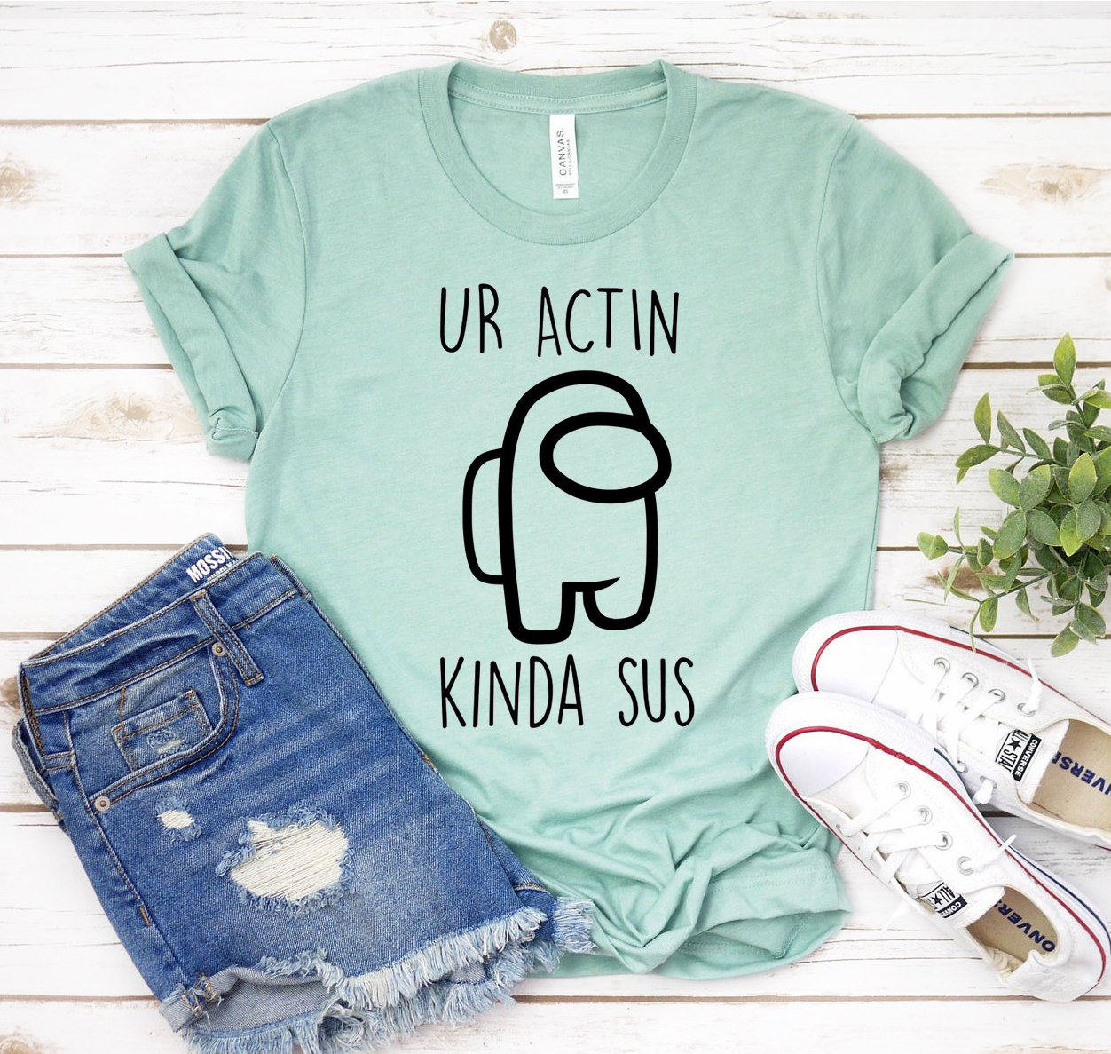 A stylish unisex T-shirt featuring the phrase 'You Are Acting Kinda Sus' in a playful font, made from soft airlume cotton.