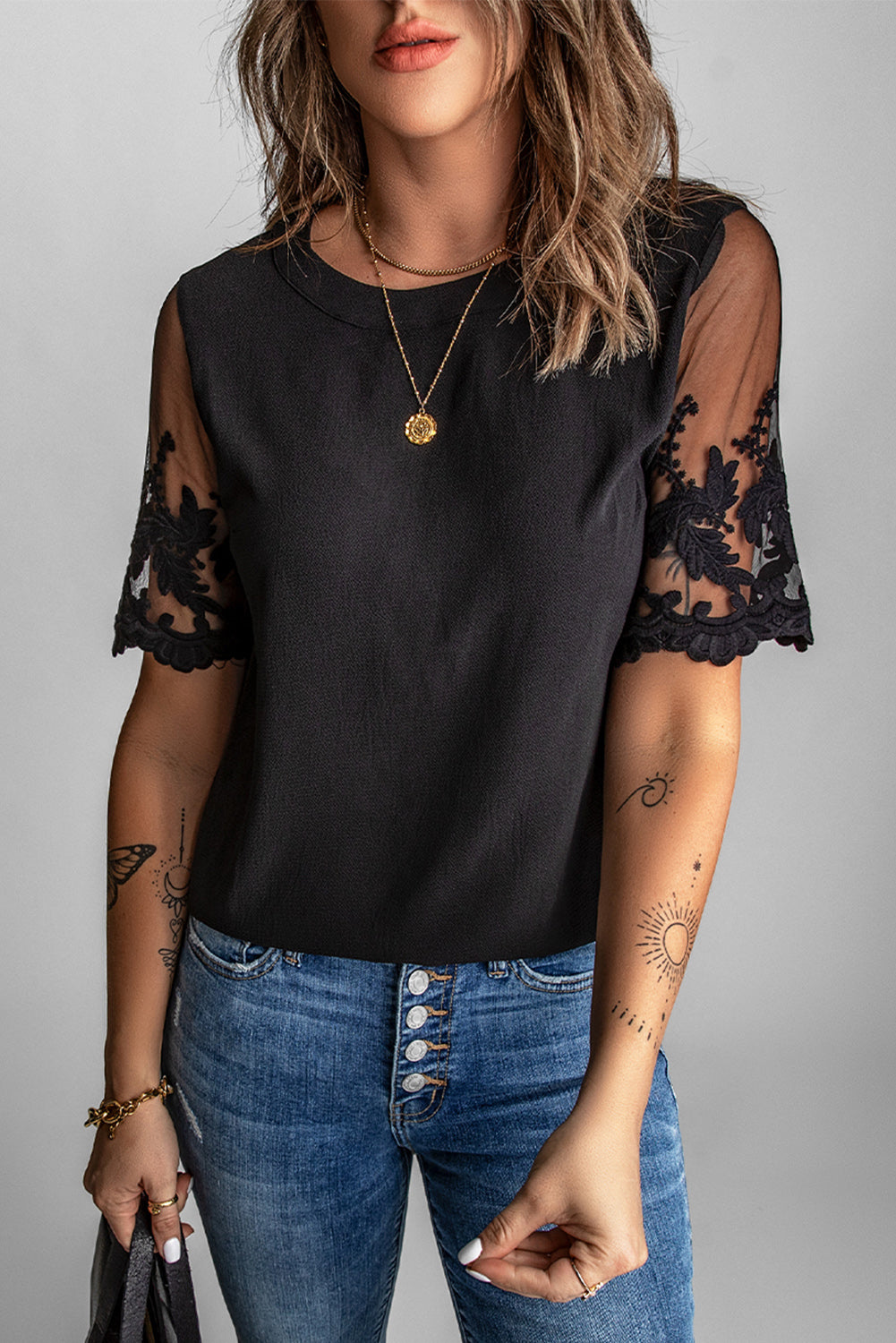 A stylish black lace short sleeve top featuring sheer floral mesh sleeves and a round neckline, perfect for summer wear.