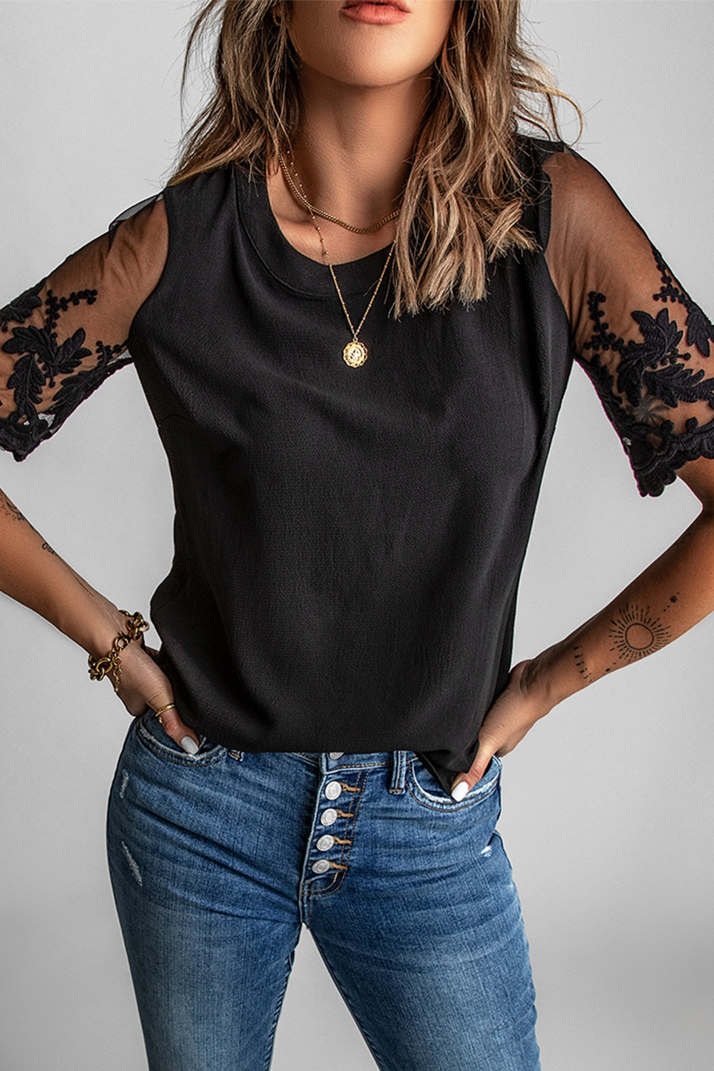 A stylish black lace short sleeve top featuring sheer floral mesh sleeves and a round neckline, perfect for summer wear.