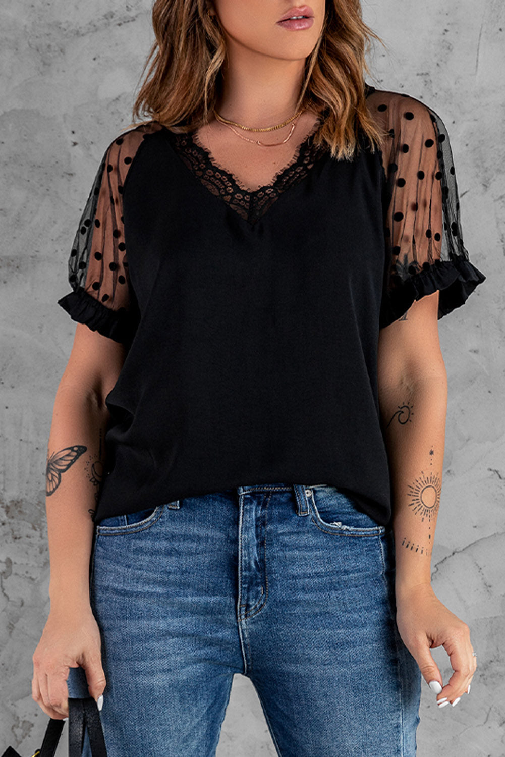 Black short sleeve blouse with polka dot print and lace neckline, perfect for summer fashion.