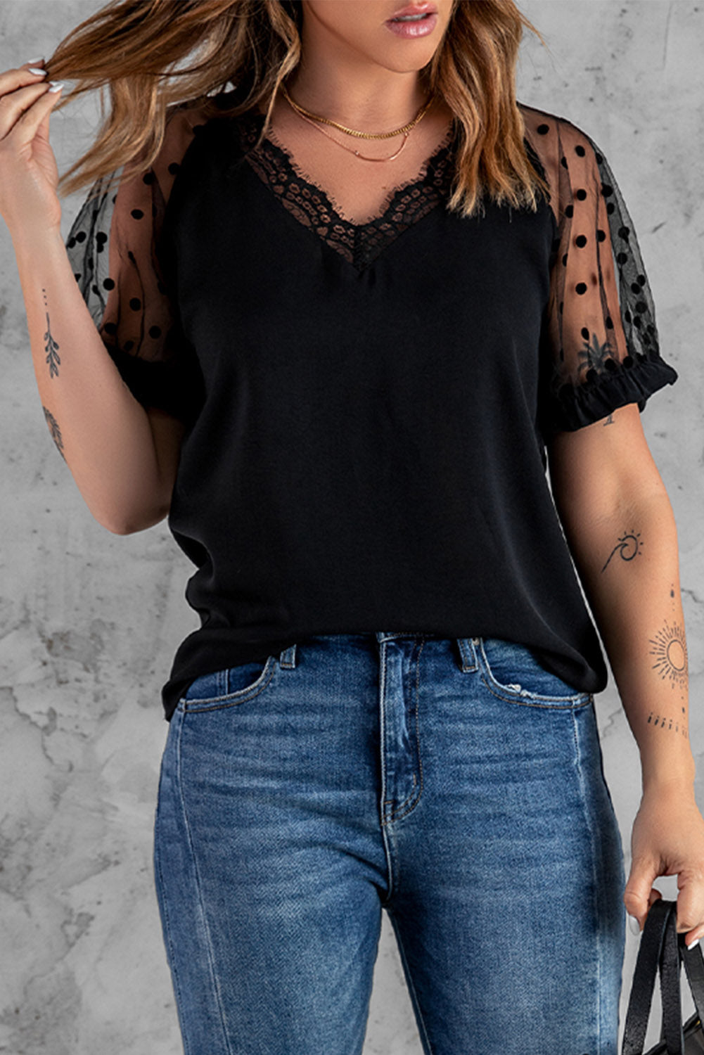 Black short sleeve blouse with polka dot print and lace neckline, perfect for summer fashion.