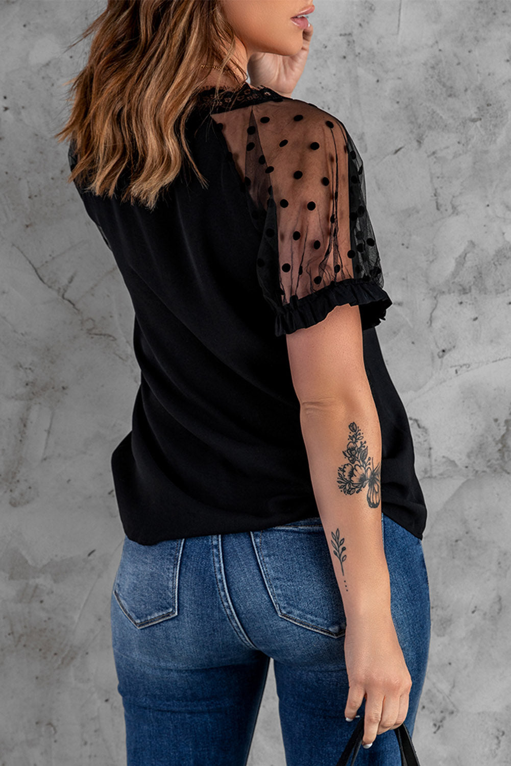 Black short sleeve blouse with polka dot print and lace neckline, perfect for summer fashion.