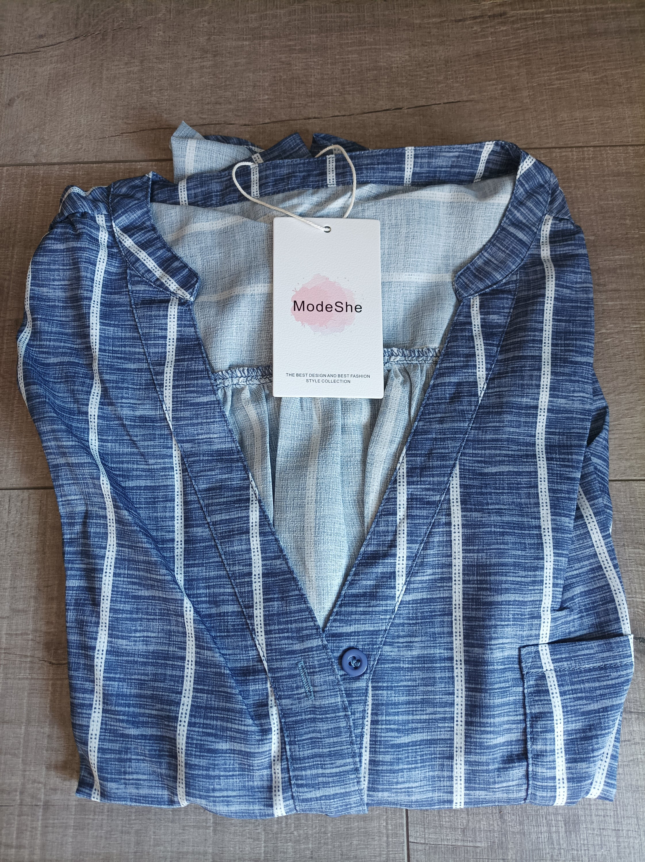 Blue striped button-down blouse with v-neckline and full sleeves, featuring a bust pocket and button cuffs.