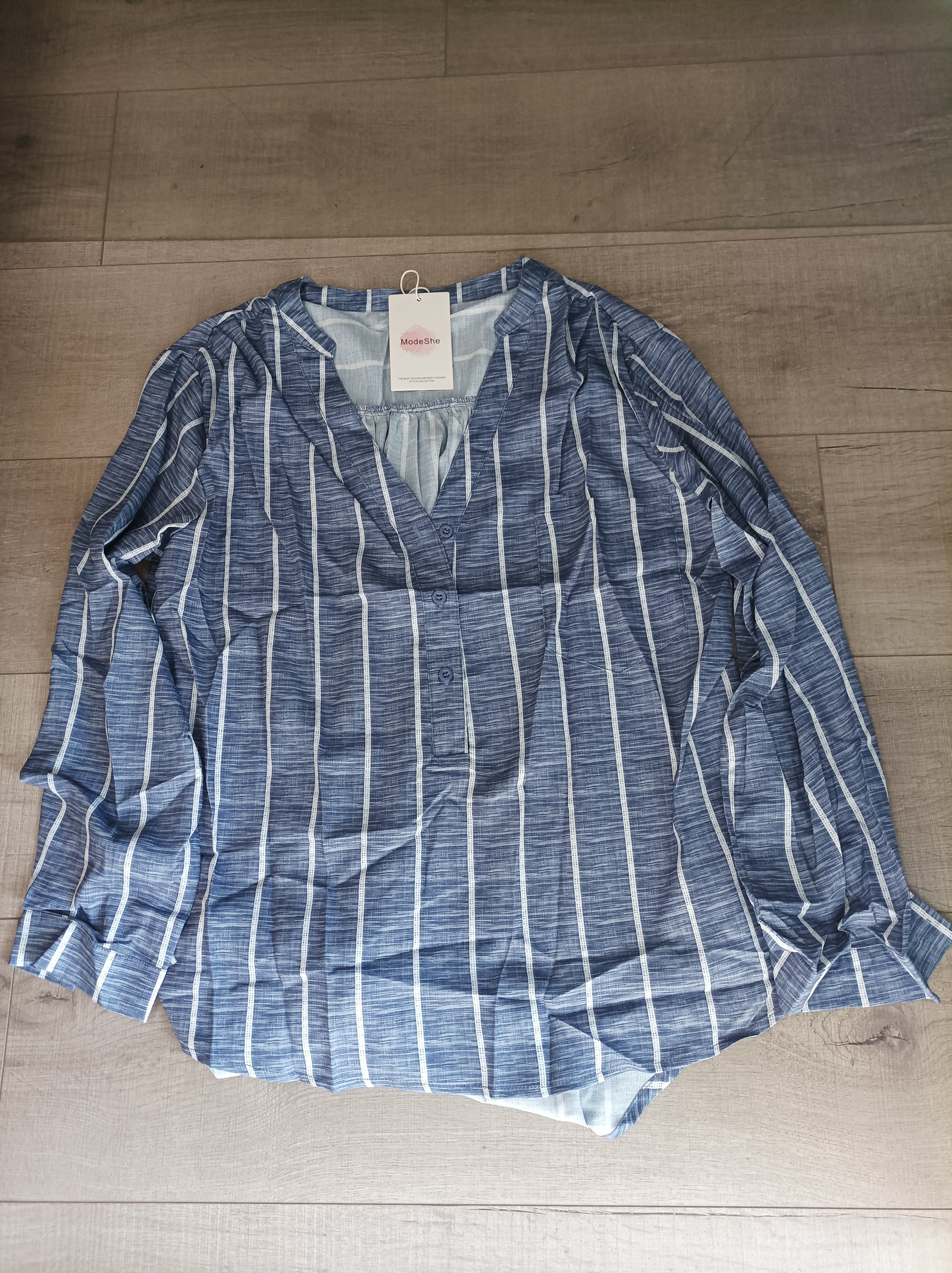 Blue striped button-down blouse with v-neckline and full sleeves, featuring a bust pocket and button cuffs.