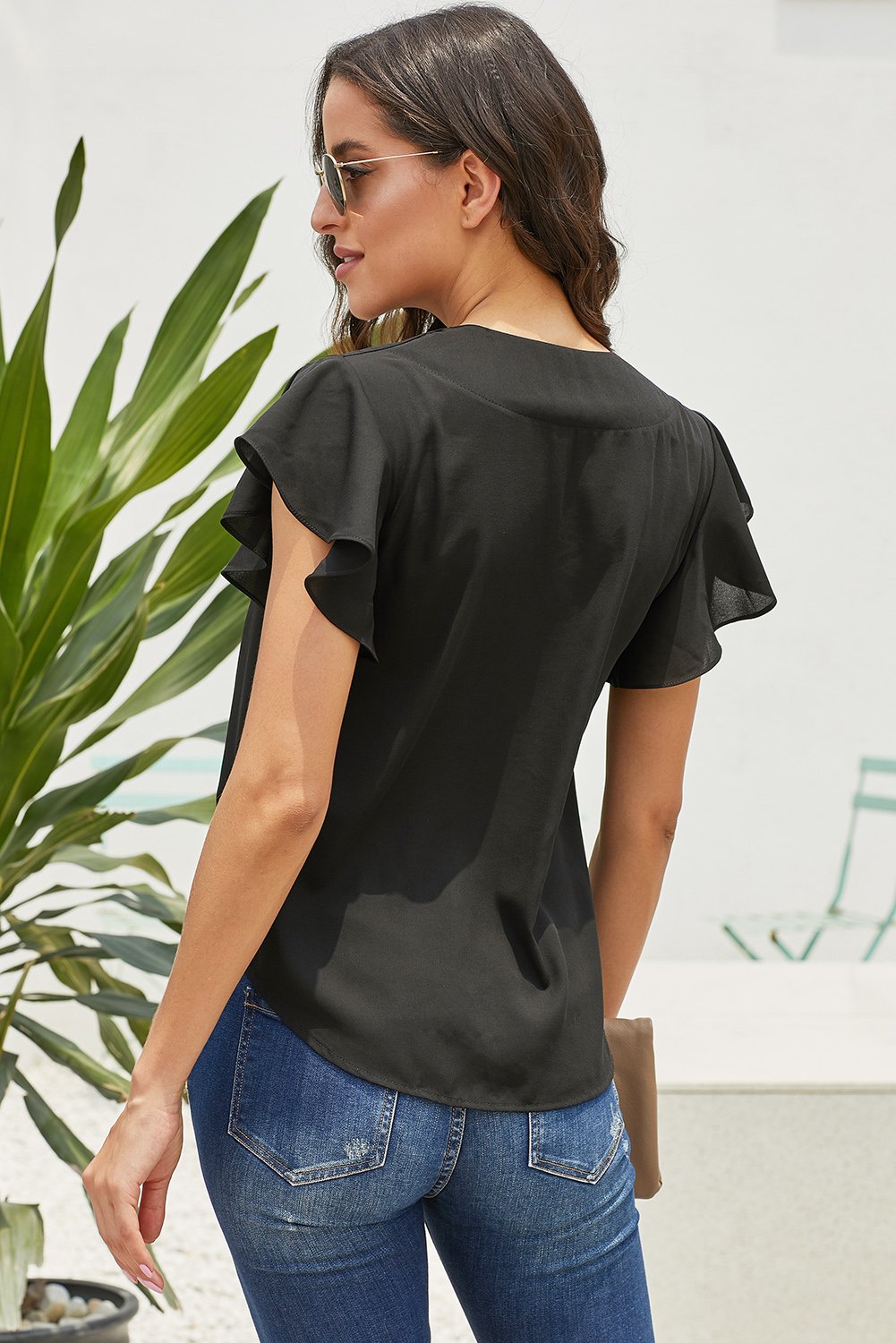 A stylish black button-down tie top featuring a deep V-neckline and fluttering short sleeves, perfect for summer wear.