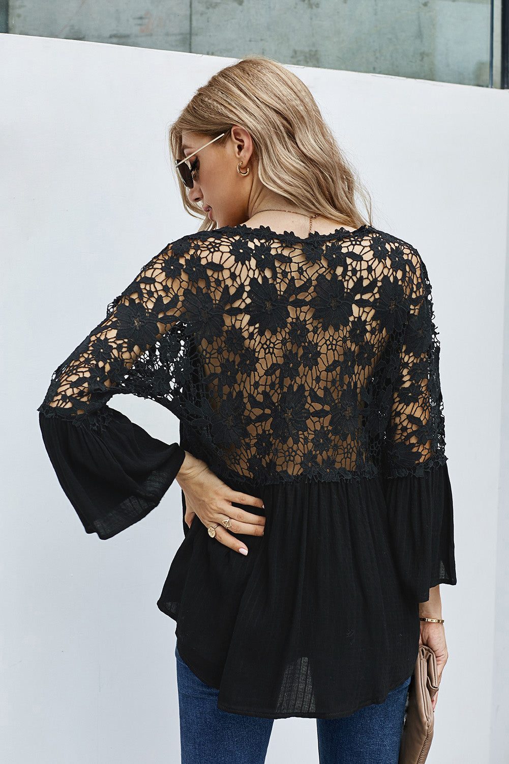 Elegant black crochet lace blouse with button front and three-quarter sleeves, perfect for casual and formal occasions.