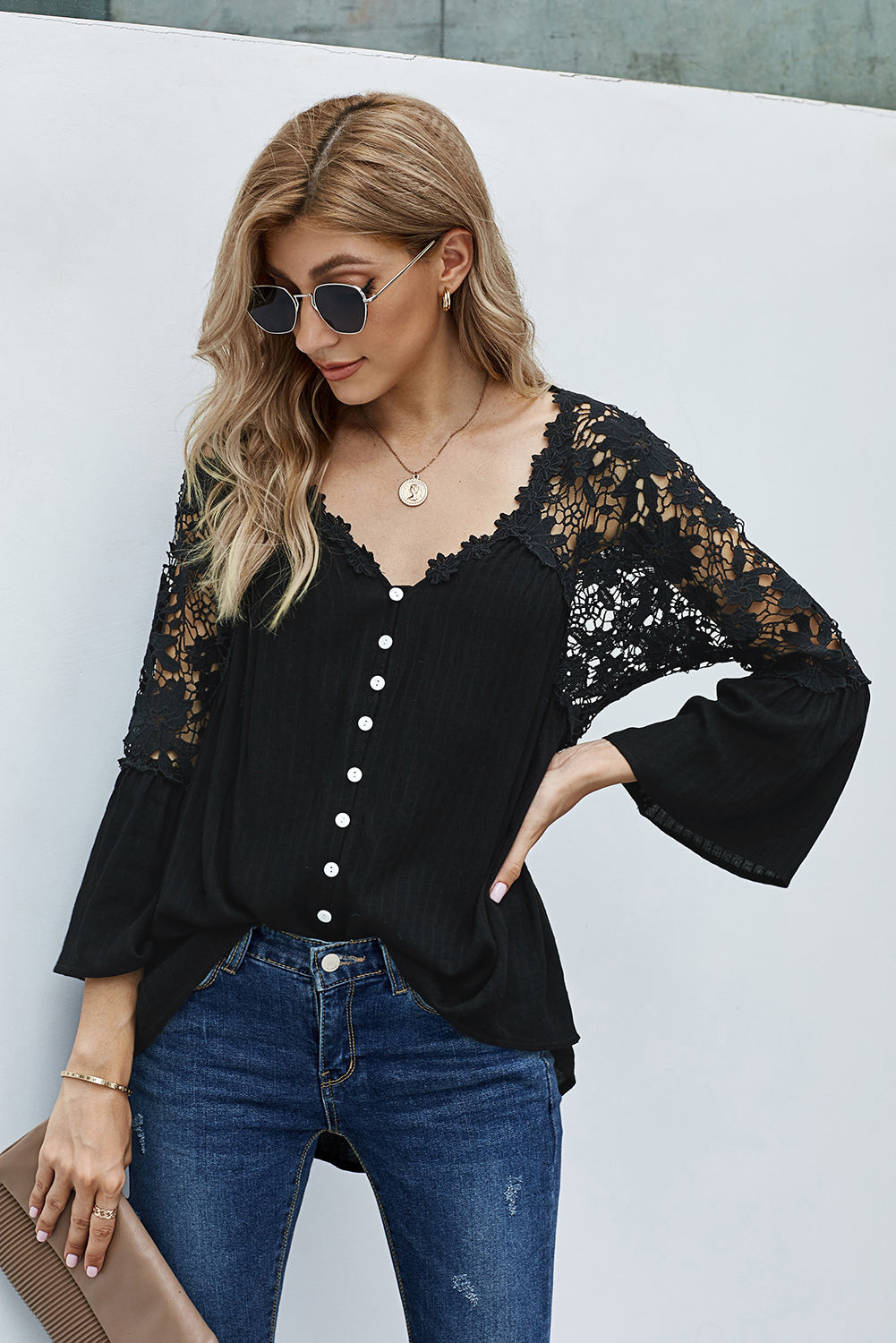 Elegant black crochet lace blouse with button front and three-quarter sleeves, perfect for casual and formal occasions.