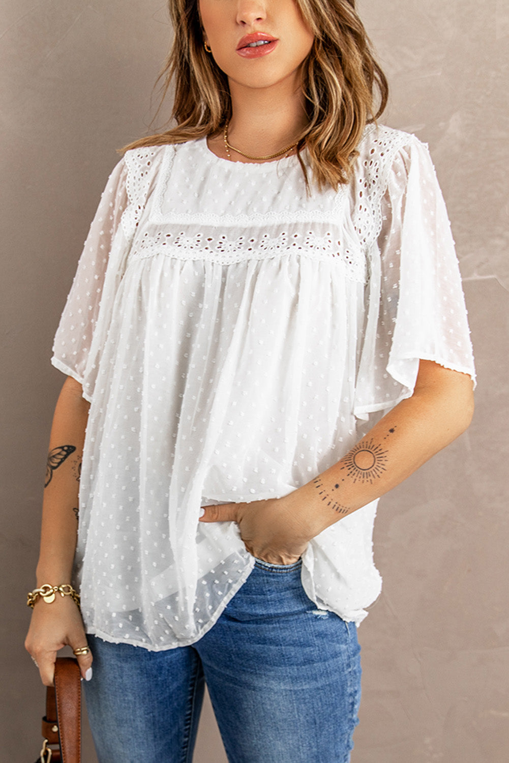 Chic white babydoll top with flutter sleeves and sheer textured design, perfect for summer wear.