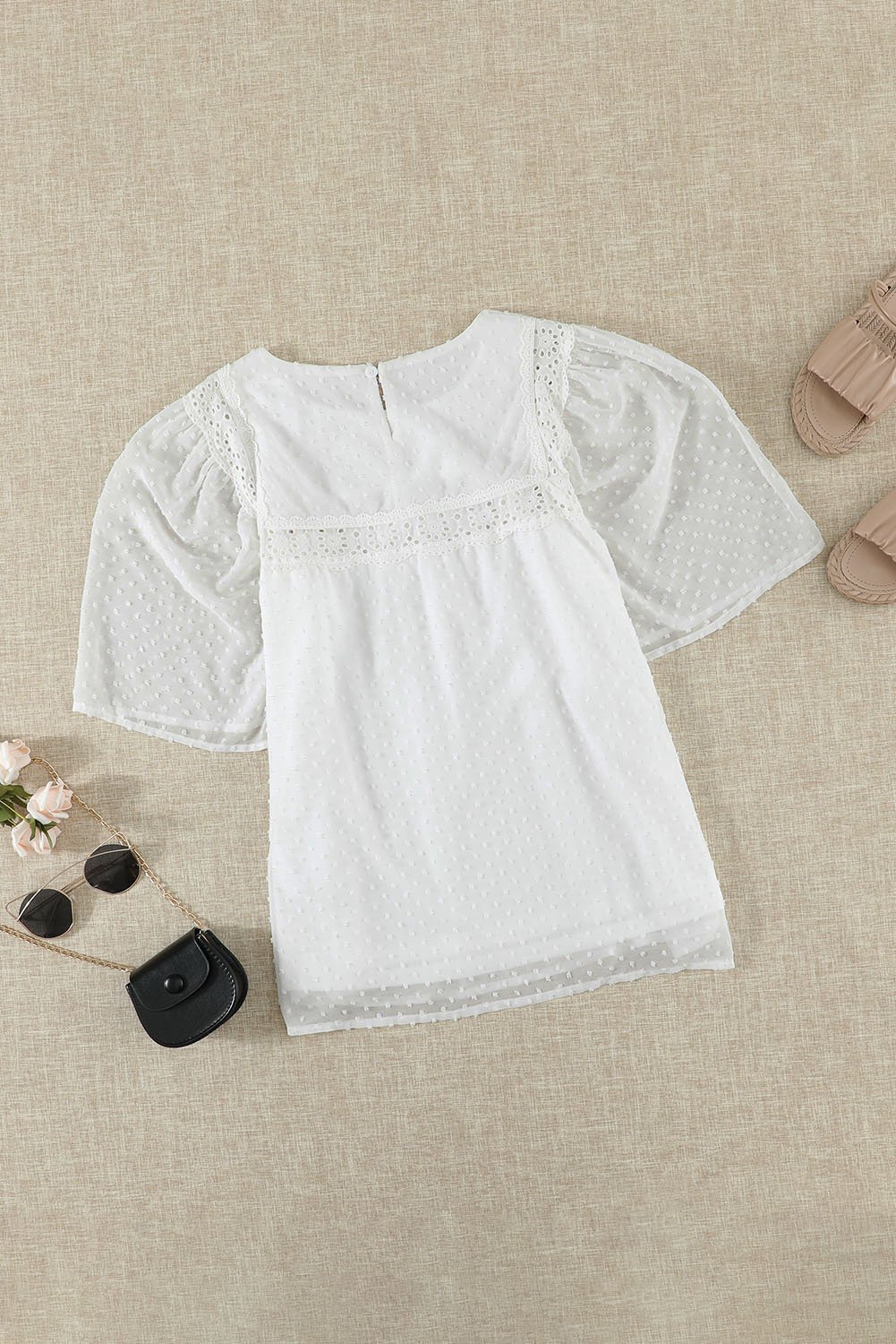 Chic white babydoll top with flutter sleeves and sheer textured design, perfect for summer wear.