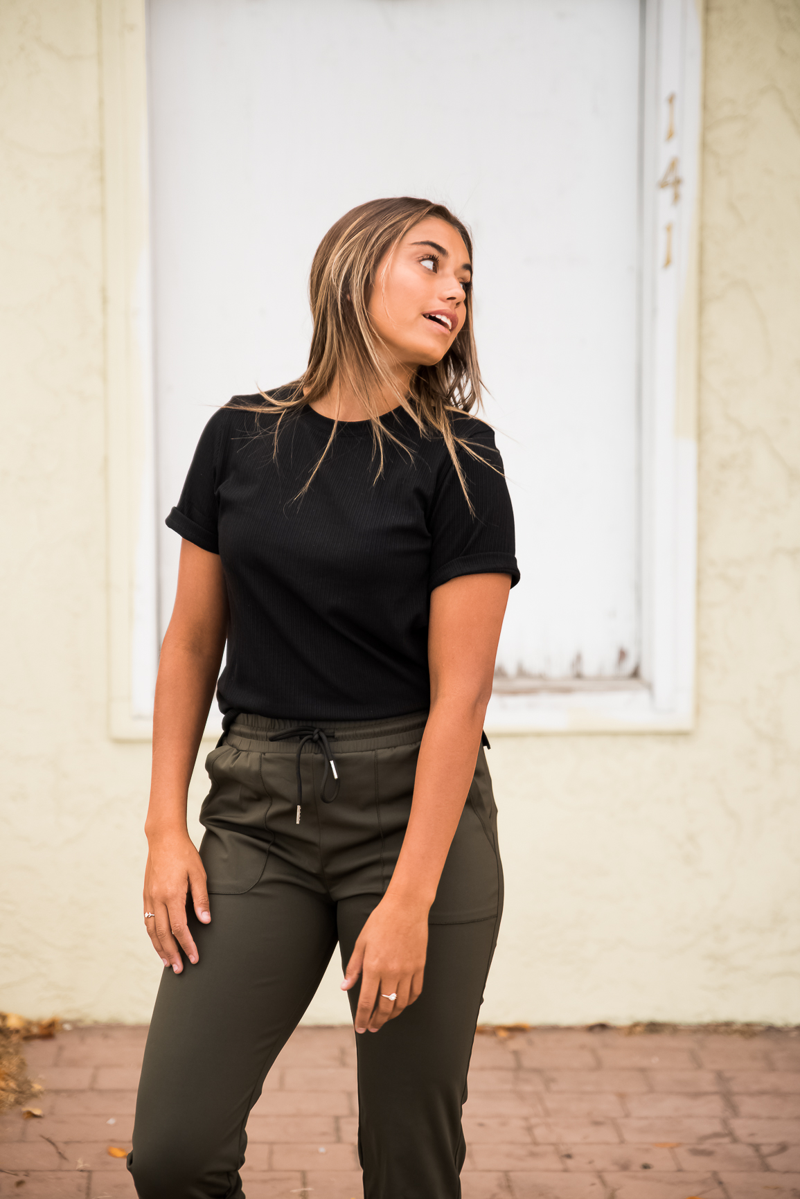 DT Alyssa Rib Knit Split Hem Tee in Black, showcasing its cozy ribbed fabric and stylish split hem design.