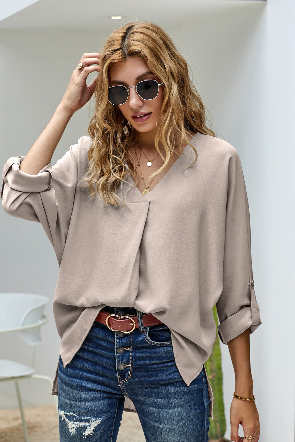 Elegant apricot v neck shirt with 3/4 sleeves and high low hem, showcasing a stylish and casual design.