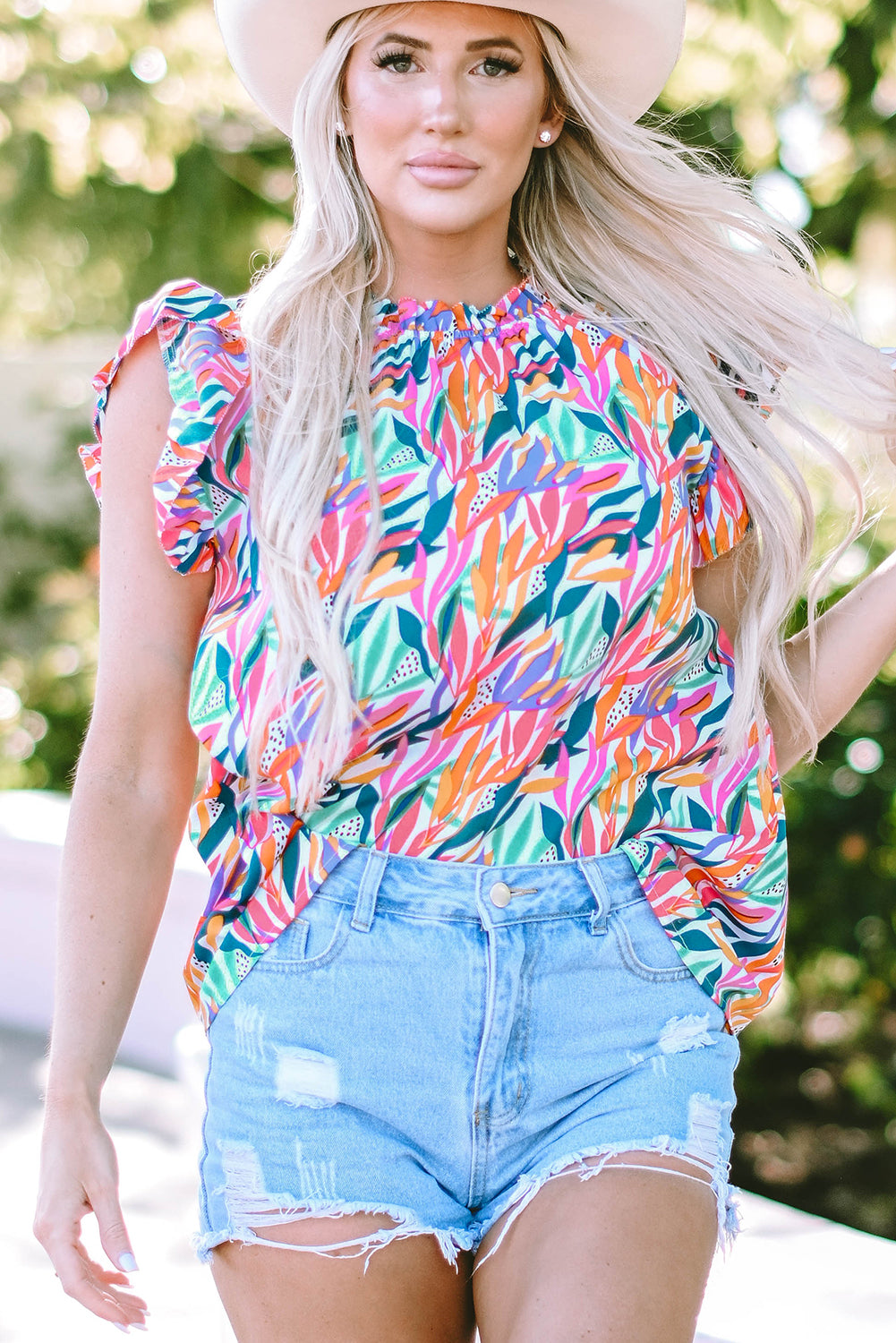 A stylish Floral Print Ruffled Blouse featuring a mock neck and flutter sleeves, adorned with a vibrant floral pattern.