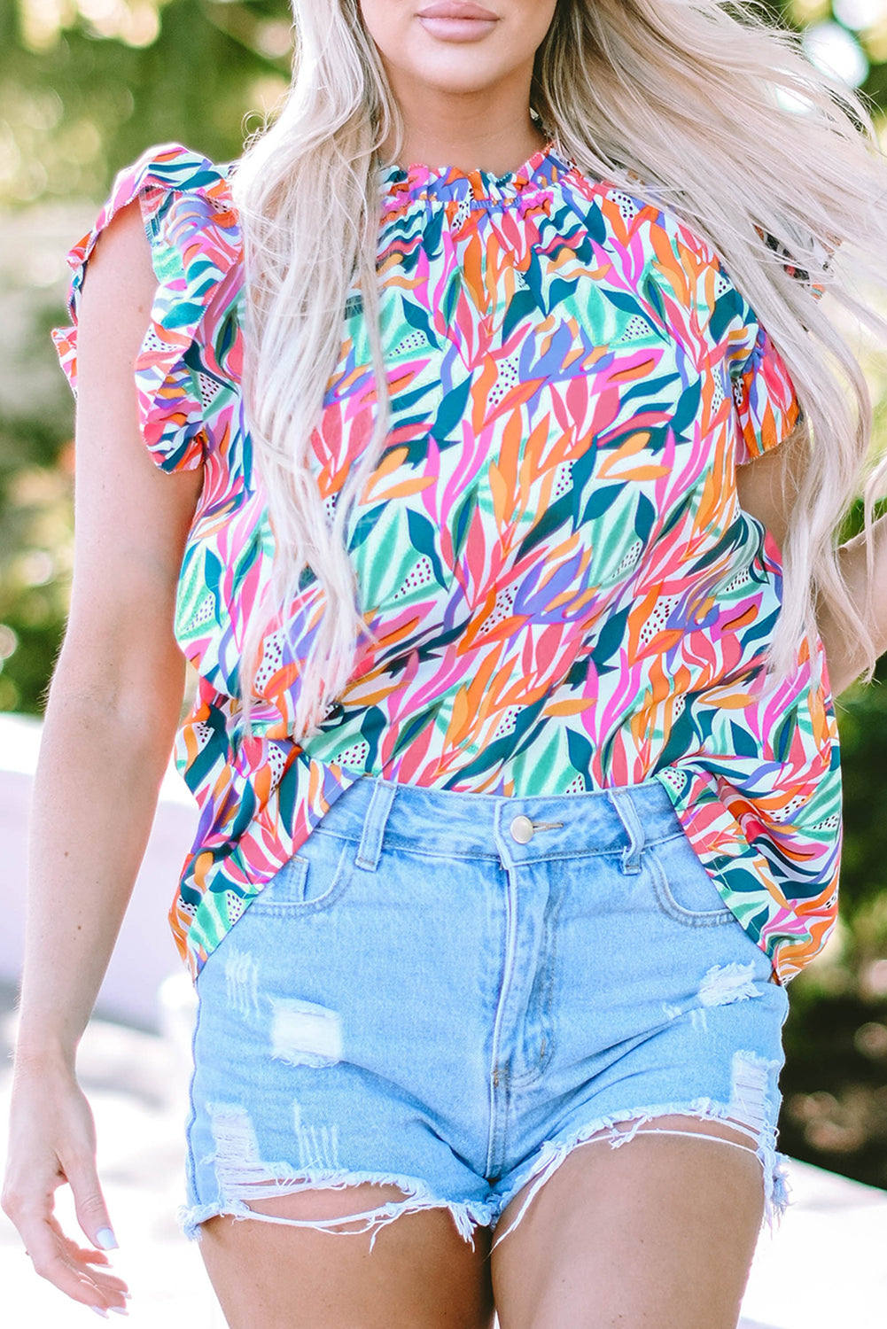 A stylish Floral Print Ruffled Blouse featuring a mock neck and flutter sleeves, adorned with a vibrant floral pattern.