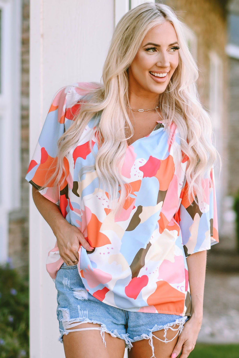 A stylish Floral Print V Neck Half Sleeve Blouse featuring a vibrant floral pattern, wide sleeves, and a flattering V-neckline, perfect for warm weather.