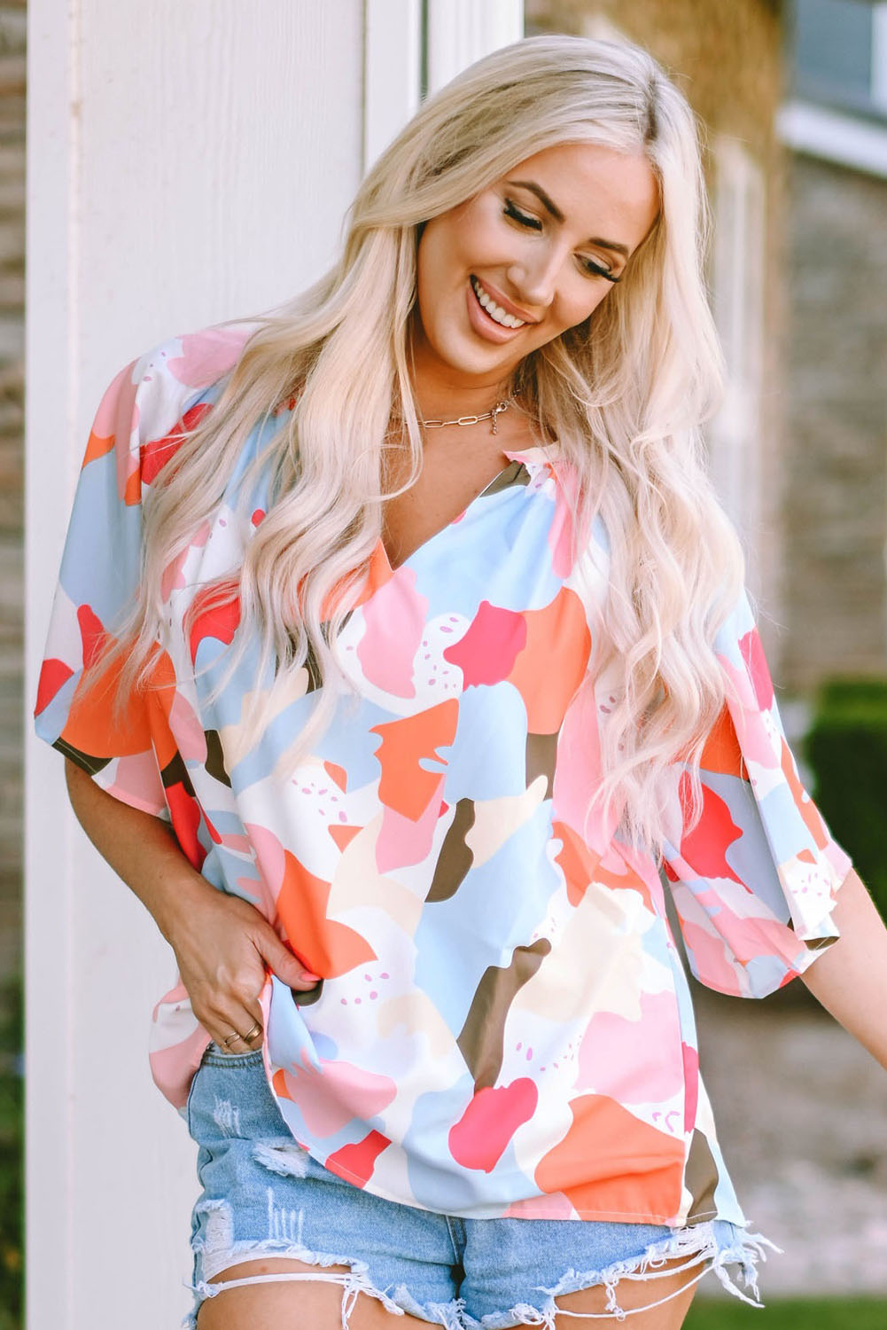 A stylish Floral Print V Neck Half Sleeve Blouse featuring a vibrant floral pattern, wide sleeves, and a flattering V-neckline, perfect for warm weather.