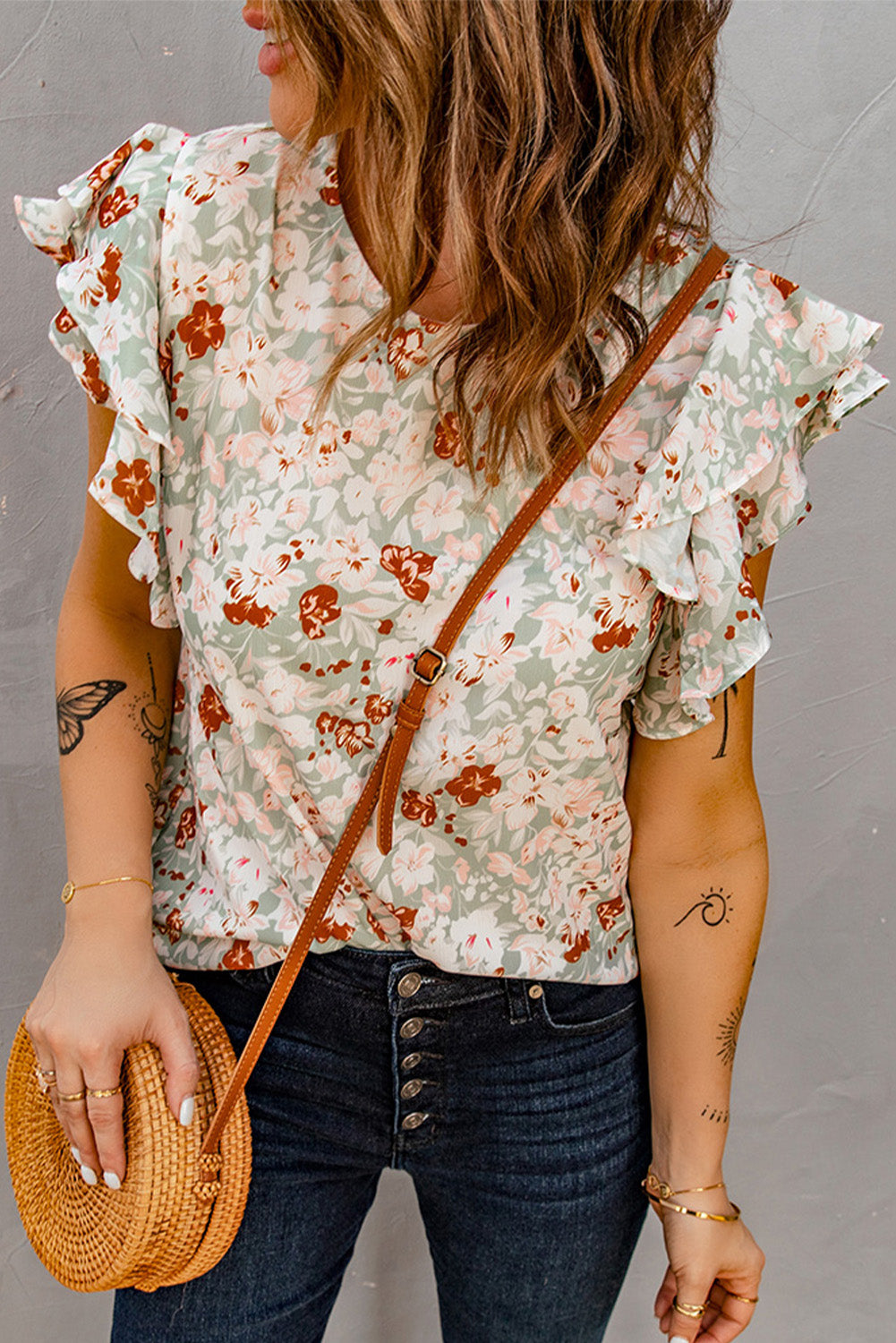 A stylish green floral ruffle short sleeve blouse featuring a floral print, flutter cap sleeves, and a back button closure, perfect for summer wear.