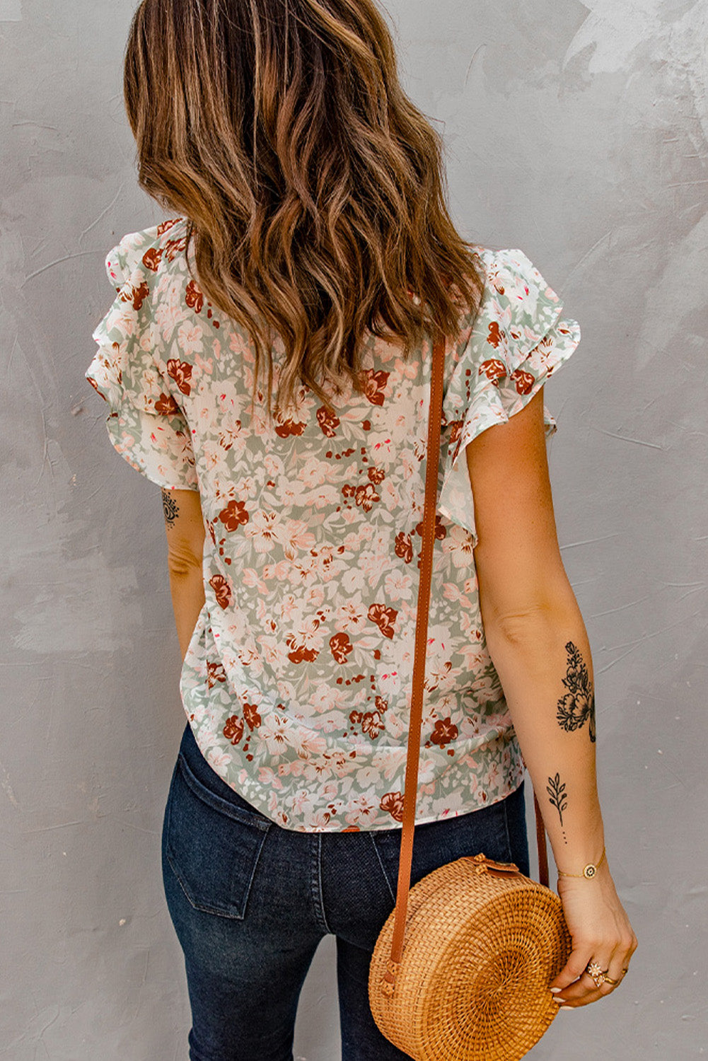 A stylish green floral ruffle short sleeve blouse featuring a floral print, flutter cap sleeves, and a back button closure, perfect for summer wear.