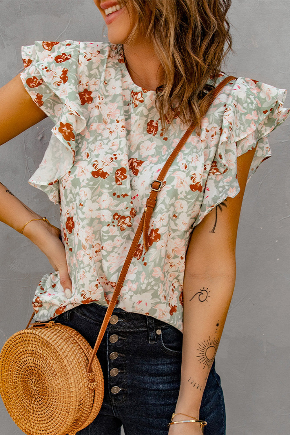 A stylish green floral ruffle short sleeve blouse featuring a floral print, flutter cap sleeves, and a back button closure, perfect for summer wear.