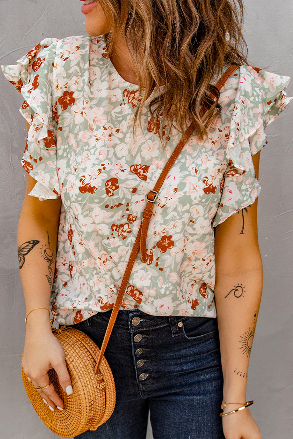 A stylish green floral ruffle short sleeve blouse featuring a floral print, flutter cap sleeves, and a back button closure, perfect for summer wear.